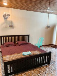 a bedroom with a bed and a blue chair at TEN STAY Homes & Independent villa in Virāmpattinam