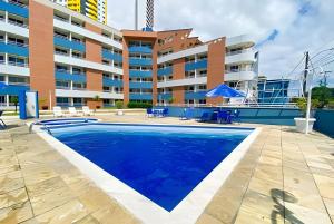 a swimming pool in front of a building at Flat no Terrazzo perto do mar in Natal