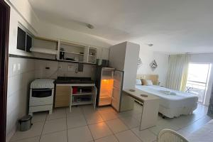 a kitchen with a refrigerator and a table in it at Flat no Terrazzo perto do mar in Natal