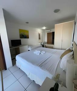 a bedroom with a large white bed in a room at Flat no Terrazzo perto do mar in Natal