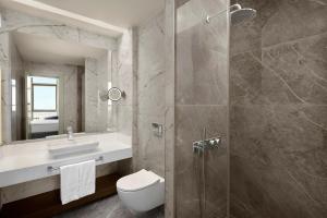 ein Badezimmer mit Toilette, Waschbecken und Dusche in der Unterkunft Concorde Tower Hotel & Casino in Lefkosa Turk