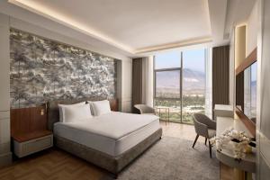 ein Hotelzimmer mit einem Bett und einem großen Fenster in der Unterkunft Concorde Tower Hotel & Casino in Lefkosa Turk
