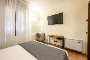 a bedroom with a bed and a tv on the wall at Emilia Studios 2 in Modena +11 photos