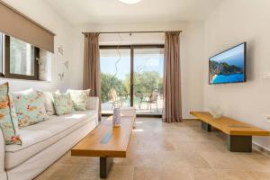 a living room with a white couch and a table at Neema Villa with Private Pool in Zakynthos