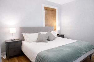 a bedroom with a large white bed with two night stands at Downtown Gem • King Bed • Fast WIFI in Salt Lake City