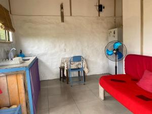 a living room with a red couch and a kitchen at Milagros in La Paloma