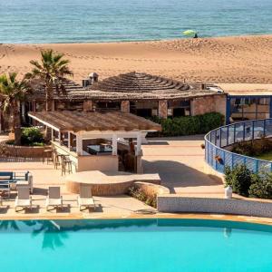 a resort with a swimming pool next to a beach at DreamCatcher Paragliders in Tamelalt