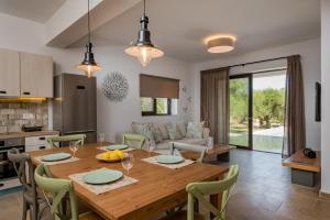 a kitchen and dining room with a wooden table and chairs at Neema Villa with Private Pool in Zakynthos
