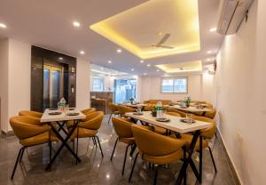 a restaurant with tables and chairs in a room at Hotel Park Tree I Sec-63A I Noida I Couple Friendly and Corporate Rooms available in Noida