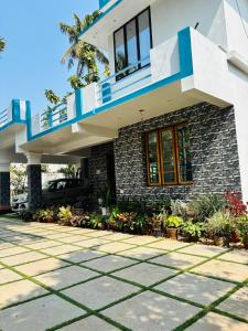 a house with a blue balcony and a driveway at A K Munroe Homestay in Munroe Island