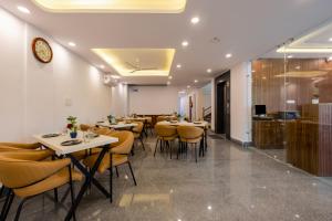 a restaurant with tables and chairs and a clock on the wall at Hotel Park Tree I Sec-63A I Noida I Couple Friendly and Corporate Rooms available in Noida