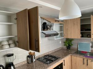 a kitchen with wooden cabinets and a counter top at bel appartement juste à côté de McDonald's in Kenitra