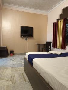 a hotel room with a bed and a flat screen tv at ADRIJA Ck 140 Saltlake SEC-ll in kolkata