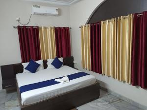 a bedroom with a bed with red and yellow curtains at ADRIJA Ck 140 Saltlake SEC-ll in kolkata