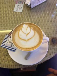 a cup of coffee sitting on a plate on a table at ADRIJA Ck 140 Saltlake SEC-ll in kolkata