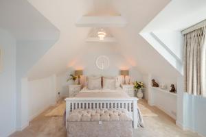 a white bedroom with a white bed in a attic at 5 Bed in Bosham oc-h33962 in Bosham