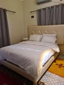 a bedroom with a large bed with white sheets and pillows at hotel and restaurant kasbah draa in Agdz