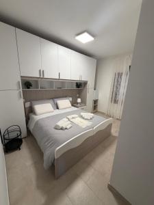 a bedroom with a large bed with white cabinets at Il Covo dell'aquila in LʼAquila