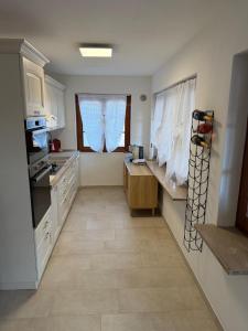 a kitchen with white cabinets and a large window at Il Covo dell'aquila in LʼAquila