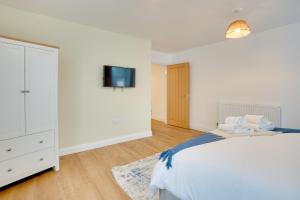 a bedroom with a bed and a tv on a wall at Apt 2 Armatage Flats, Eyemouth in Eyemouth