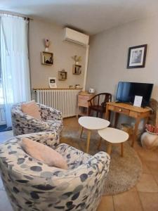 a living room with two chairs and a table at Mas Bella Vida - Chambres d'Hôtes in Puget-Théniers