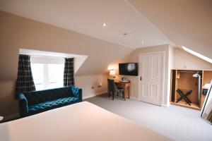 a room with a bed and a couch and a desk at The Seafield Arms-Cullen in Cullen +76 photos