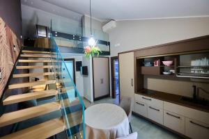 a room with a staircase and a table and a kitchen at Le 2 Palme Apartments in Catanzaro Lido