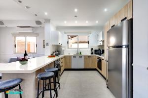 a kitchen with wooden cabinets and a stainless steel refrigerator at Beachfront Villa Carpe Diem in Mor Menekshe