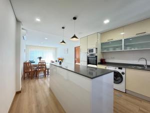 a kitchen with white cabinets and a counter top at Refugio do Atlântico in Marinhas
