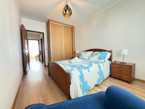 a bedroom with a bed and a blue couch at Refugio do Atlântico in Marinhas +25 photos