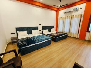 two beds in a room with wooden floors at The Laxman Palace in Ayodhya
