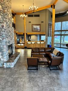 a living room with a couch and a stone fireplace at River Lodge and Cabins in Boardman