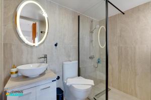 a bathroom with a toilet and a sink and a mirror at Beachfront Villa Carpe Diem in Mor Menekshe