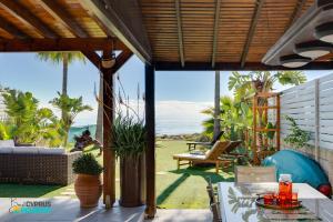 an outdoor patio with a view of the ocean at Beachfront Villa Carpe Diem in Mor Menekshe
