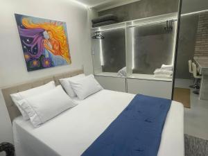 a bedroom with a bed with a painting on the wall at Studio Arte de Cuidar in Campinas