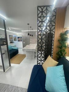 a living room with a blue couch and a kitchen at Studio Arte de Cuidar in Campinas