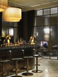 a bar with stools in a room with windows at Hotel Capital in Zagreb