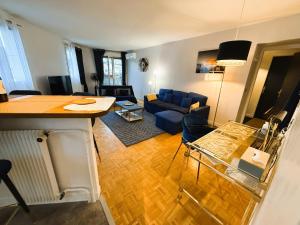 a living room with a blue couch and a table at Blue Haven Sèvres in Sèvres