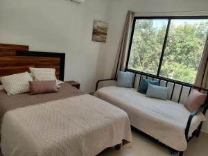 a bedroom with two beds and a large window at Casa de lujo en Playa del Carmen in Playa del Carmen +21 photos