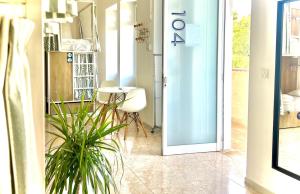 a door leading into a room with a table and a plant at Follow the Sun Boutique Hostel - Pool, Breakfast & Sea Views in St. Julianʼs