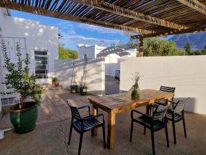 a wooden table and chairs on a patio at Karoocible Cycling House in Ladismith