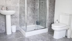 a bathroom with a shower and a toilet and a sink at AMETHYST - 4br all with ensuite & parking in Cambridge +41 photos