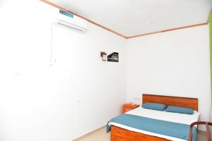 a white bedroom with a bed and a chair at AERO View Villa in Induruwa