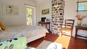 a bedroom with a bed and a table and a chair at Mas Bella Vida - Chambres d'Hôtes in Puget-Théniers +45 photos