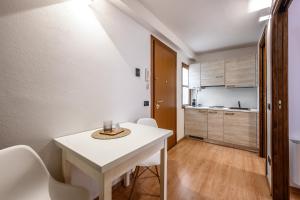 a small kitchen with a white table and chairs at Emilia Studios 7 in Modena +11 photos