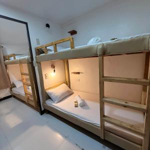 two bunk beds in a room with a mirror at Camila Hostel Coron in Coron +27 photos