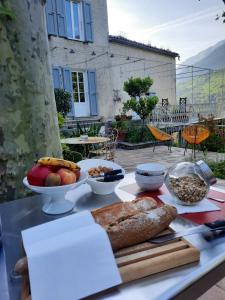 a table topped with different types of bread and fruit at Mas Bella Vida - Chambres d'Hôtes in Puget-Théniers