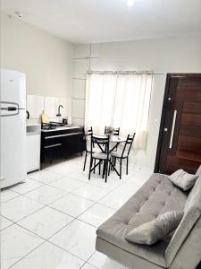 a kitchen with a couch and a table with chairs at Studio Confortável no Centro com Garagem in Araquari