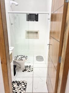 a bathroom with a toilet and a glass shower at Studio Confortável no Centro com Garagem in Araquari +19 photos
