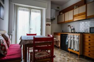 a kitchen with a table with chairs and a kitchen with a stove at Casa Gabry - your first step in the Dolomites in Belluno